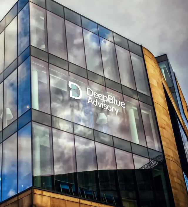 The DeepBlue Advisory logo on the glass facade of an office building